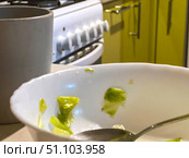 There is a bowl of leftover food on the table with a spoon in it. Стоковое фото, фотограф Ярославский Максим / Фотобанк Лори