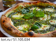 Delicious neapolitan pizza with fresh basil and melted mozzarella on pesto sauce. Стоковое AI-изображение, AI-художник Иван Рябоконь / Фотобанк Лори