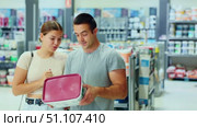 Spouses buyers with cans of paint in hands choice and closely examines product, enamel dye. Стоковое видео, видеограф Яков Филимонов / Фотобанк Лори