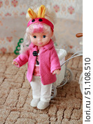 Pink-Coated Doll Strolling in Style: Miniature Fashion Meets Childhood Playtime. Редакционное фото, фотограф Максимова Марина / Фотобанк Лори