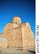 Stepantsminda, Georgia - January 03, 2023: Gergeti Church of the 14th century at the foot of Mount Kazbek. Редакционное фото, фотограф Наталия Кирсанова / Фотобанк Лори