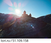Stepantsminda, Georgia - January 03, 2023: Gergeti Church of the 14th century at the foot of Mount Kazbek. Редакционное фото, фотограф Наталия Кирсанова / Фотобанк Лори