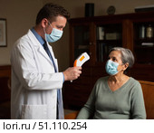 A man in a white lab coat is taking a woman's temperature with a thermometer. Стоковое AI-изображение, AI-художник Ярославский Максим / Фотобанк Лори