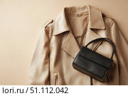 Beige leather jacket with zippers and pockets and black leather stylish bag. Modern outerwear. Close-up. Fashion background. Autumn urban street clothes. Fashionable concept. Women's casual day outfit. Стоковое AI-изображение, AI-художник Марина Демидюк / Фотобанк Лори