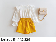 Fashion look of baby girl clothes and accessories. Set of muslin blouse, shorts, hairband and bag. Trendy cute tuff background for newborn. Toddler apparel. Female kid outfit. Pastel child wear set. Стоковое AI-изображение, AI-художник Марина Демидюк / Фотобанк Лори