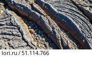 Geology background concept with layered volcanic rock formation texture, abstract nature wallpaper showing closeup of solidified lava flow patterns from volcano eruption. Стоковое фото, фотограф Павел Муравьев / Фотобанк Лори