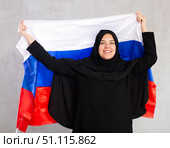 Happy young woman dressed in traditional islamic clothes with russian flag. Стоковое фото, фотограф Яков Филимонов / Фотобанк Лори