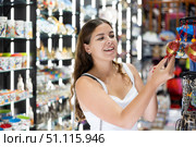 Cheerful young girl viewing funny items displayed in souvenirs shop. Стоковое фото, фотограф Яков Филимонов / Фотобанк Лори