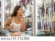 Interested young woman viewing various swords placed on display case. Стоковое фото, фотограф Яков Филимонов / Фотобанк Лори