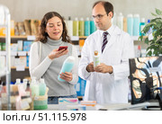 Woman buyer scans shampoo qr code with man pharmacist. Стоковое фото, фотограф Яков Филимонов / Фотобанк Лори