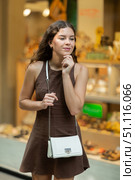 Beautiful young girl customer choosing something in souvenir shop during tourist trip in Spain. Стоковое фото, фотограф Яков Филимонов / Фотобанк Лори