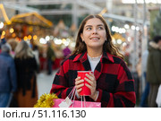 Happy girl with paper cup of coffee walking in Christmas fair. Стоковое фото, фотограф Яков Филимонов / Фотобанк Лори