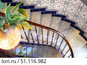 Spiral staircase. Top view. Chandelier and ceramic tiles on the wall. Стоковое фото, фотограф Евгений Ткачёв / Фотобанк Лори