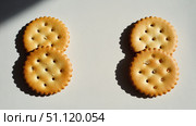 There are two pairs of round crackers on a white background, neatly stacked on top of each other. Each cracker has fluted edges and holes. Стоковое AI-изображение, AI-художник Светлана  Громак / Фотобанк Лори