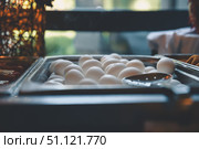 Piled high in a metal serving tray, white eggs await breakfast or brunch, complemented by a metal slotted spoon resting conveniently on top, ready for serving. Стоковое фото, фотограф Ольга Ильина / Фотобанк Лори