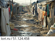 Makeshift laundry drying in a refugee camp slum. Стоковое AI-изображение, AI-художник Иван Рябоконь / Фотобанк Лори