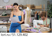 Young tailoress drawing sketches and man sewing in workshop. Стоковое фото, фотограф Яков Филимонов / Фотобанк Лори
