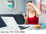 Girl with a headache complains to the doctor on the Internet using laptop. Стоковое фото, фотограф Яков Филимонов / Фотобанк Лори