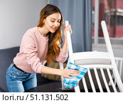 Young woman wipes a chair with a damp cloth. Стоковое фото, фотограф Яков Филимонов / Фотобанк Лори