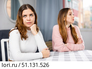 Upset woman sitting at home table with disgruntled woman behind. Стоковое фото, фотограф Яков Филимонов / Фотобанк Лори