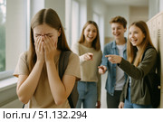 A Scene of School Bullying: A Young Girl in Distress While Peers Laugh and Point, Highlighting the Emotional Impact of Teasing and Social Exclusion. Стоковое AI-изображение, AI-художник Башкирова Анна / Фотобанк Лори