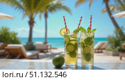Освежающие коктейли с лаймом и мятой на пляжном столике / Refreshing cocktails with lime and mint on a beachside table. Стоковое AI-видео, аниматор DeFusum / Фотобанк Лори