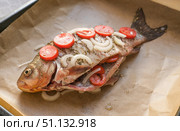 Fresh whole river crucian fish on parchment with tomatoes and spices ready for baking. Стоковое фото, фотограф Екатерина Золина / Фотобанк Лори