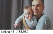 A warm moment between parent and child, showing a tender embrace. A father holds his young son in his arms and kisses him. Close-up. Стоковое видео, видеограф Воловодов Владимир / Фотобанк Лори