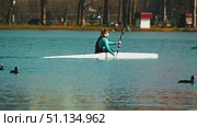 A woman kayaking on a serene lake. Athletes training on open water. Birds flying overhead, adding dynamics. Water sports. Krasnodar, Russia, March 3, 2025. Редакционное видео, видеограф Воловодов Владимир / Фотобанк Лори