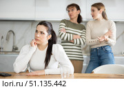 Upset middle-aged woman sitting at the kitchen table with her back to women quarreling to her. Стоковое фото, фотограф Яков Филимонов / Фотобанк Лори