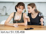 Middle-aged woman sitting at table while another woman trying to calm her sitting by her side. Стоковое фото, фотограф Яков Филимонов / Фотобанк Лори