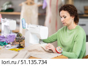 Female tailor using sewing machine to make garment in studio. Стоковое фото, фотограф Яков Филимонов / Фотобанк Лори