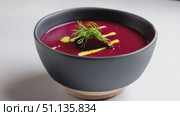 Dark gray ceramic bowl holding vivid beetroot cream, sprinkled with fresh dill, drizzled with glistening olive oil, spinning slowly on clean white surface. Стоковое AI-видео, аниматор Юрий Поздников / Фотобанк Лори