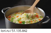 Steaming couscous with vibrant vegetables simmering in traditional pot, wooden spoon lifting fragrant, colorful vegetarian meal against dark, rustic background. Стоковое AI-видео, аниматор Юрий Поздников / Фотобанк Лори