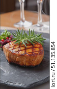 Grilled tuna steak seasoned with rosemary, resting on black slate, accompanied by roasted vegetables and chilled white wine glasses nearby. Стоковое AI-видео, аниматор Юрий Поздников / Фотобанк Лори