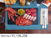 Top view of sliced gammon, chorizo, salami, bacon on slate board. Стоковое фото, фотограф Яков Филимонов / Фотобанк Лори