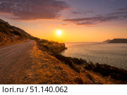 Sunrise on the island of Crete near Spinalonga with sea coast, rocks and dirt road. (2019 год). Стоковое фото, фотограф Емельянов Евгений Викторович / Фотобанк Лори