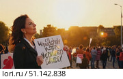 A participant holds a sign, expressing concern during a sunset protest in the heart of the city. Стоковое AI-видео, аниматор Данила Большаков / Фотобанк Лори