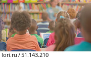 Kids listen intently to a storyteller during an afternoon session at the community library. Стоковое AI-видео, аниматор Данила Большаков / Фотобанк Лори