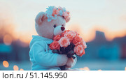 Heartwarming image of plush teddy bear wearing charming flower crown and holding vibrant bouquet of peach and pink roses, set against dreamy, soft-focus background with warm sunset and cool tones. Стоковое AI-изображение, AI-художник Данила Большаков / Фотобанк Лори
