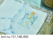 Krasnodar, Russia. July 17, 2022: An embroidered icon on a baptismal garment for a baby. The art of embroidery. Редакционное фото, фотограф Наталия Кирсанова / Фотобанк Лори