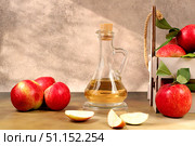 Apple cider vinegar or fermented drink and fresh apples on a sunny table. Autumn banner. Diet and weight loss concept. Healthy eating, body detoxification, apples help cleanse the body. Стоковое фото, фотограф Светлана Балынь / Фотобанк Лори