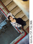 The girl is standing inside an industrial or residential building. A landing, an unkempt building. Women's clothing style is free. Стоковое фото, фотограф Наталия Кирсанова / Фотобанк Лори