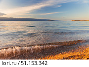 Baikal Lake at summer sunset. Olkhon Island. Sandy and pebbles beach of Small Sea with pure transparent clear water in July hot day. Natural background. Summer travel and seaside recreation. Стоковое фото, фотограф Виктория Катьянова / Фотобанк Лори