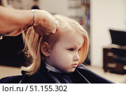 Little Girl Experiences First Haircut at a Cozy Hair Salon With a Gentle Stylist. Стоковое фото, фотограф Aleksandr Golubev / Фотобанк Лори