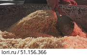 The chef stirs steaming rice in a large pilaf cauldron with a slotted spoon. Стоковое видео, видеограф Aleksey Kidisyuk / Фотобанк Лори