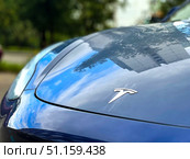 A blue car with the letter "T" on the hood. There is a Tesla car in the parking lot. Russia. Moscow. 22.08.25. Редакционное фото, фотограф Ярославский Максим / Фотобанк Лори