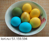 Colorful Easter eggs lie in a white porcelain plate. Blue, green, yellow, Golden eggs. Стоковое фото, фотограф Олег Тараканов / Фотобанк Лори