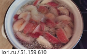 Close-up of apples boiling in a pot with water. The process of making homemade fruit compote from fresh apples. Boiling, bubbles on the surface, natural food and a cozy kitchen atmosphere. Стоковое видео, видеограф Андрей Жигальцов / Фотобанк Лори