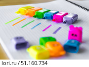 Bright multicolored highlighter pens placed in a creative row on squared paper, with bold fluorescent marker strokes showing each color. The vivid neon tones create a vibrant and playful layout, ideal for educational content, school advertising, creative workspaces and office organization concepts. Стоковое фото, фотограф Анастасия Мерчик / Фотобанк Лори